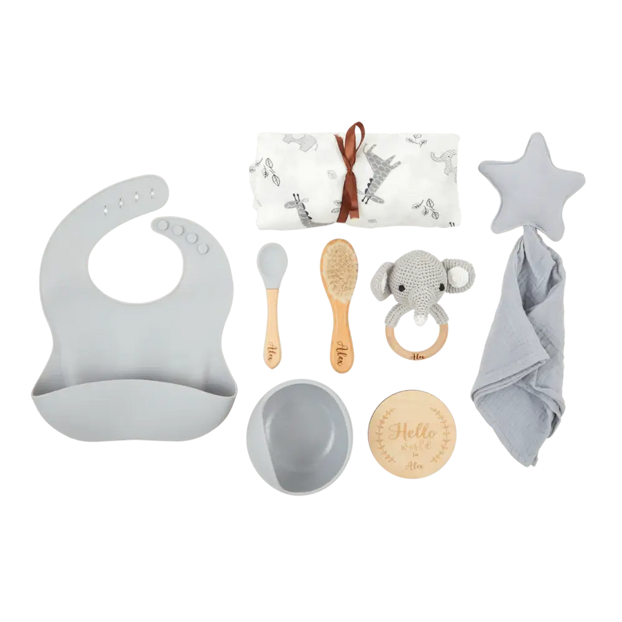 A personalised set of baby gift items including a grey elephant rattle, a star-shaped comforter, a engraved baby name hairbrush, a personalised spoon, a bowl, soft cotton and bamboo swaddle blanket and other feeding accessories.