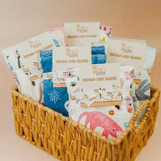 Basket of baby blankets with various designs and 'Newly Born' branding.