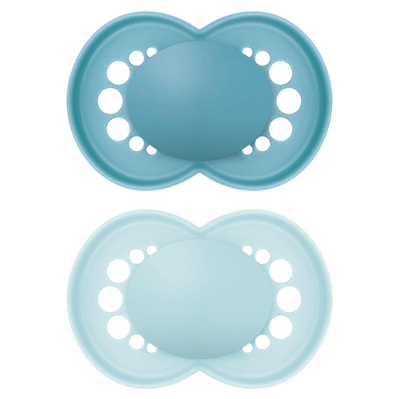 Two blue silicone pacifiers with holes on a white background