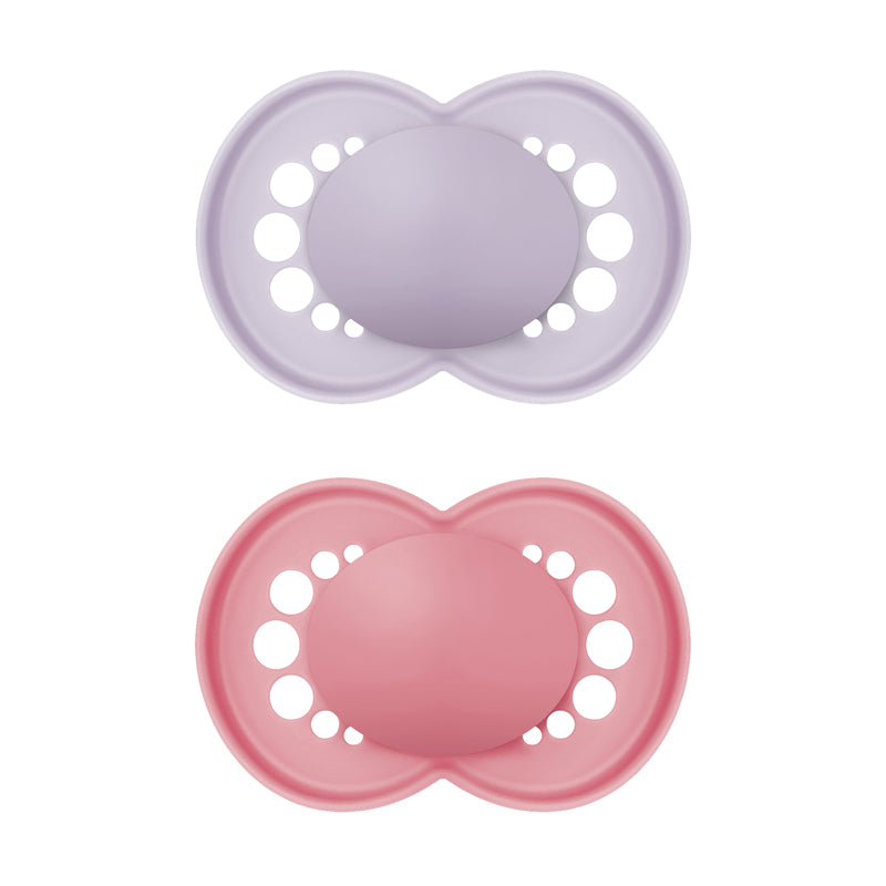 Two silicone pacifiers, one purple and one pink, on a white background