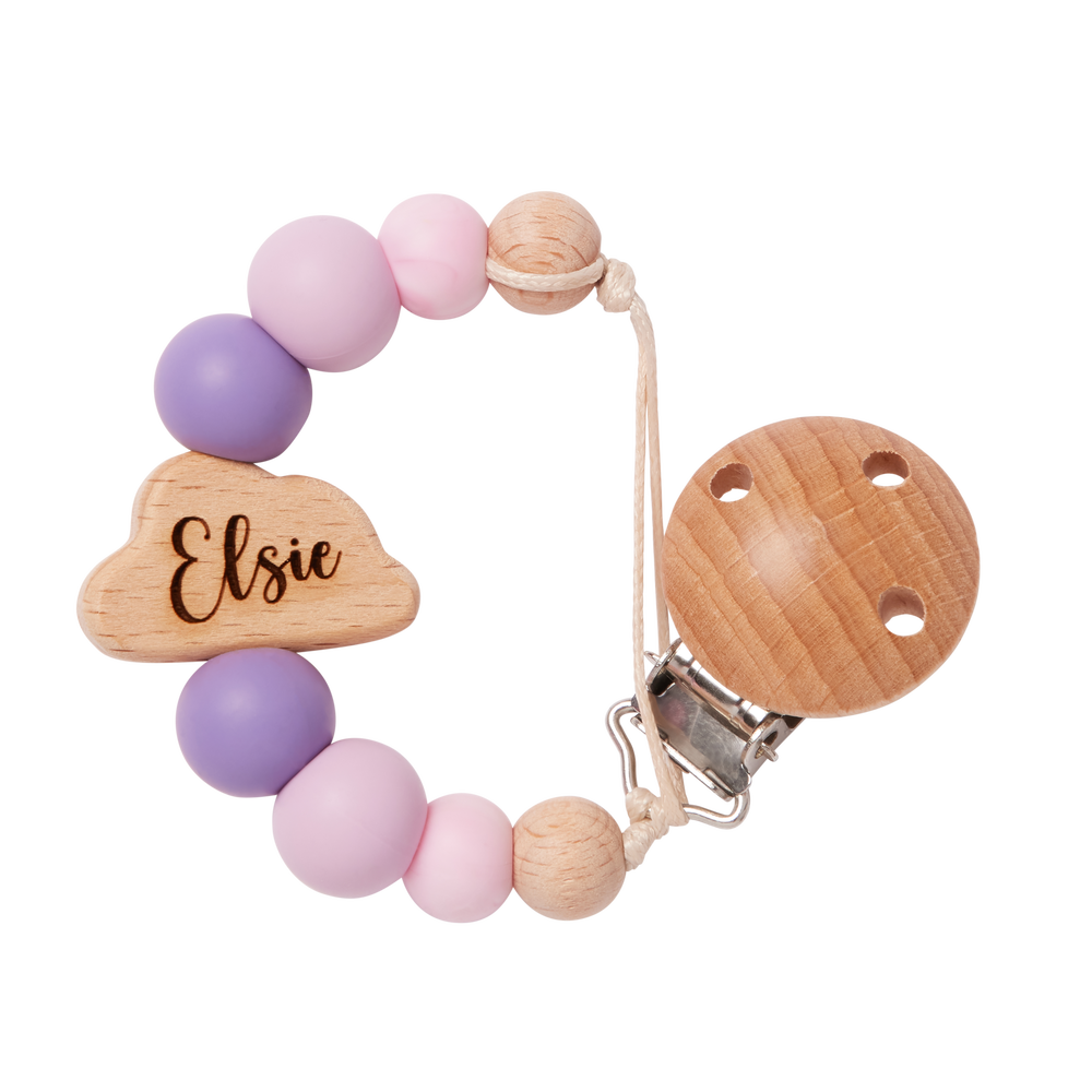 Teething ring with pruple and pink beads and wooden components on a white background engraved with name 'Elise'