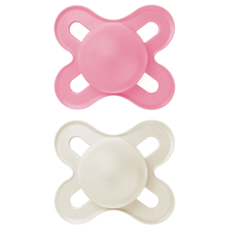 Two baby pacifiers, one pink and one beige, on a white background
